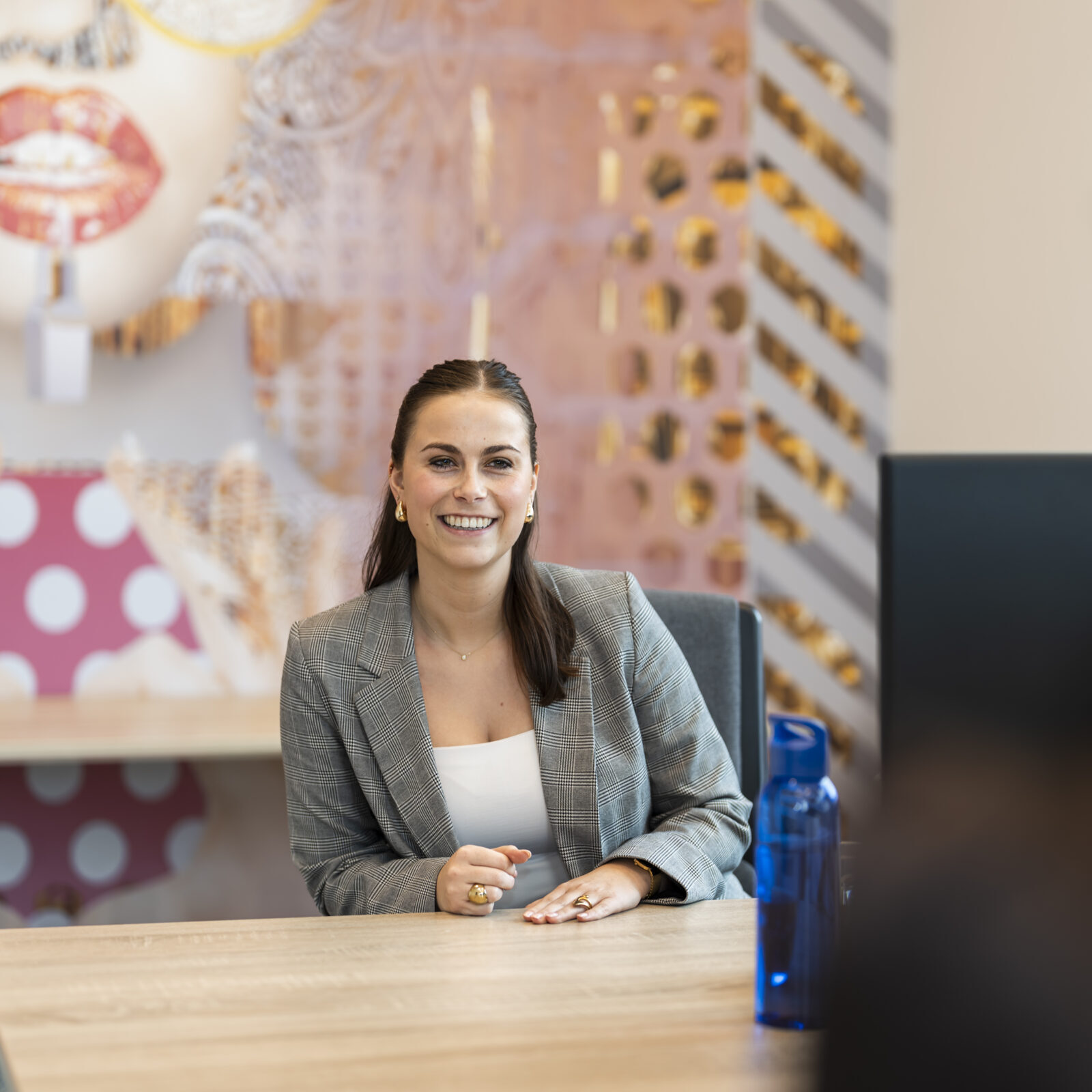 Medewerker Wex Holland van afdeling HR lachend achter een bureau