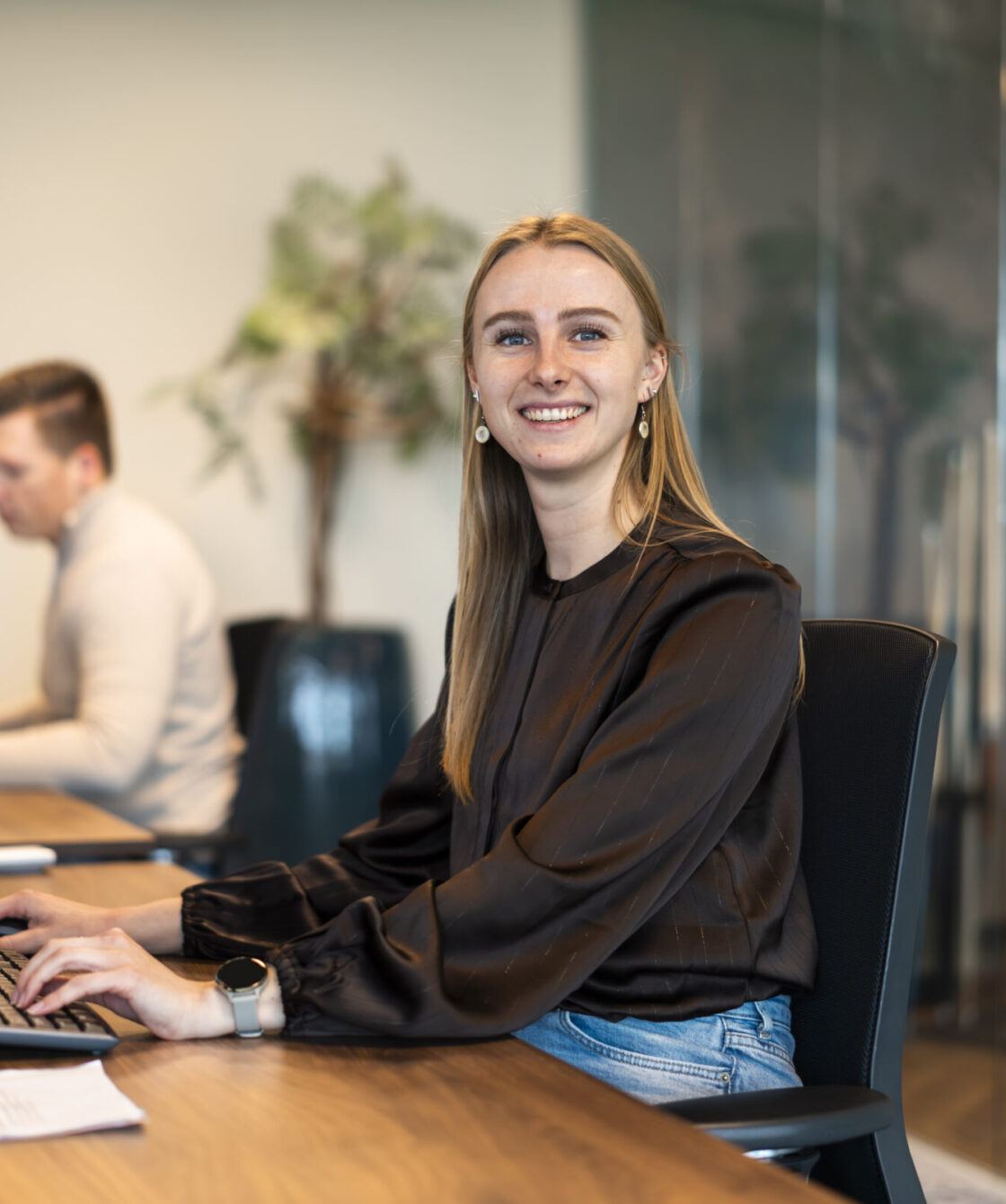 Wex Holland medewerker manager van marketing & finance lachend van achter een bureau