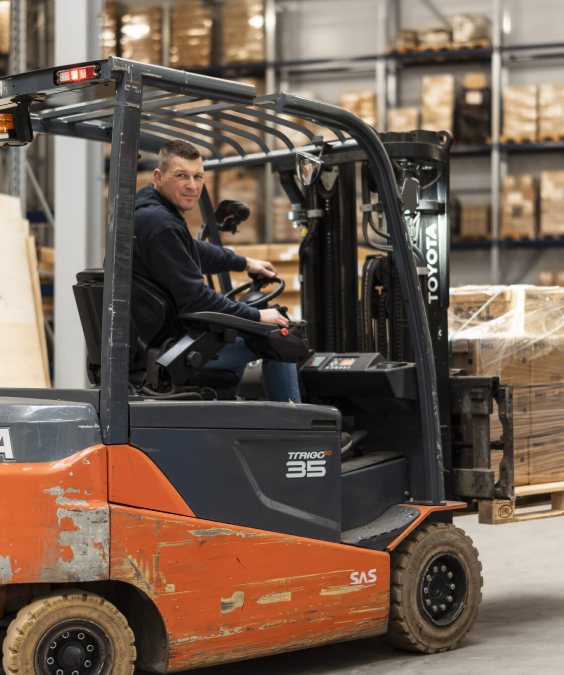Medewerker Wex Holland uit het Warehouse rijdend in een heftruck met een lading