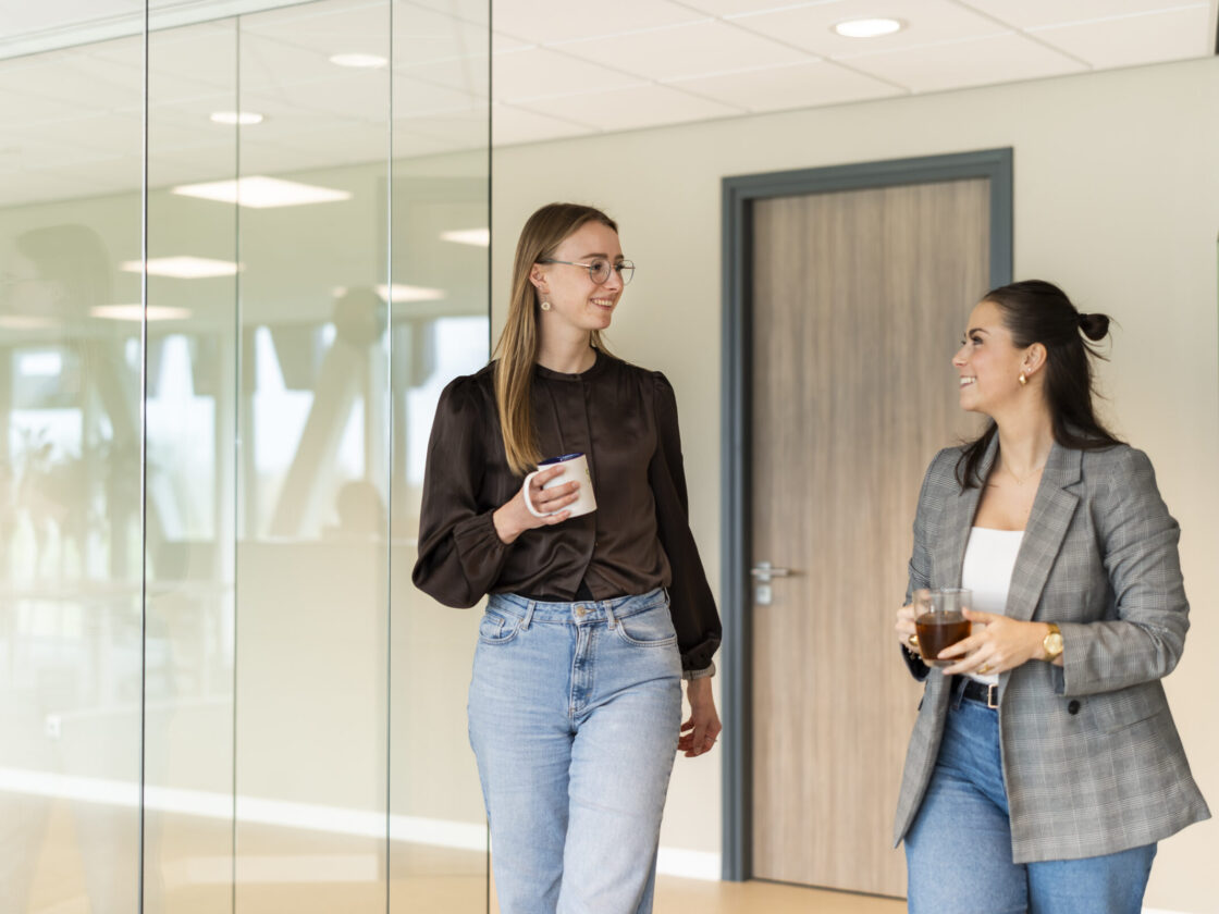Medewerkers Wex Holland van afdeling HR lopend door een gang van het Wex Holland kantoor