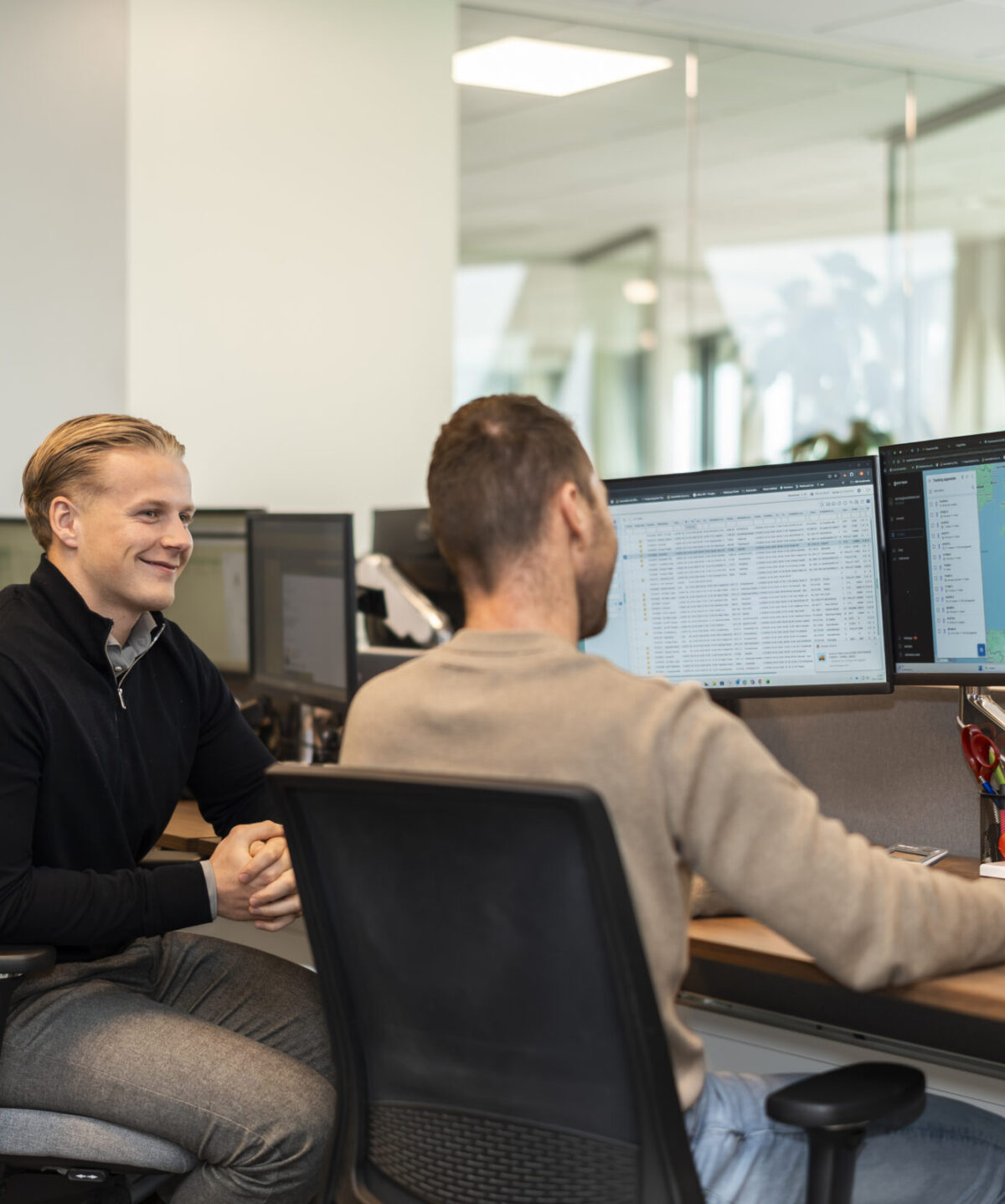 Wex Holland medewerkers transportplanners kijkend en lachend naar een planbord